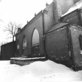 Skats uz baznīcas ziemeļaustrumu fasādi, priekšplānā bunkurs akmeņogļu uzglabāšanai. Baznīcas sānu logi pārveidoti, to augšdaļa aizmūrēta. Foto fiksācija 1983. gada februāris. 